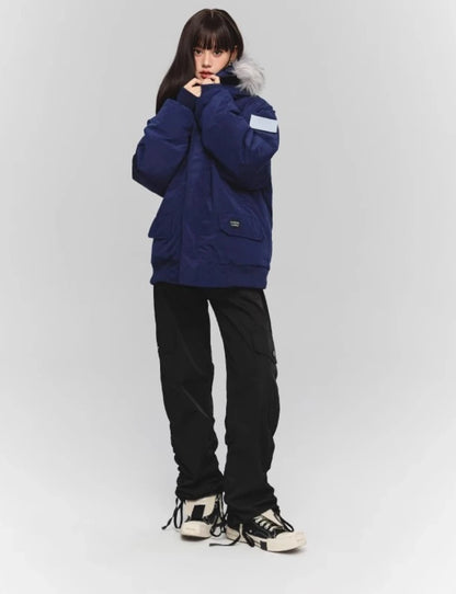 ネイビーのダウンと黒のワイドカーゴパンツの全身コーデ。フードに手を添えるポーズ。