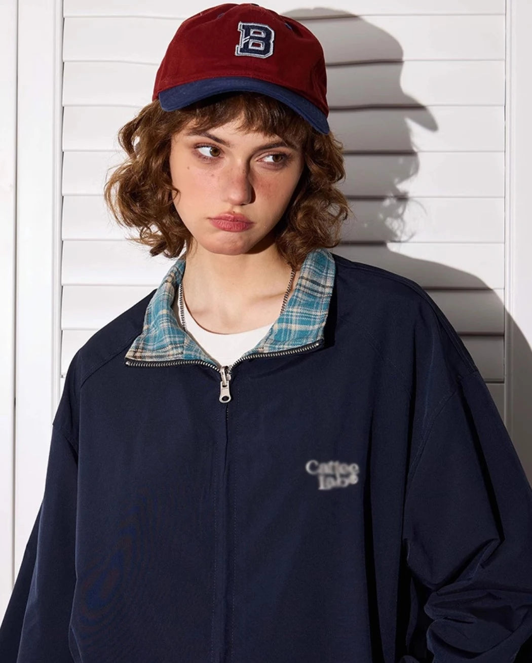 ネイビー無地側のリバーシブルジャケットを着たモデル。少し不満げな表情、クローズアップ。