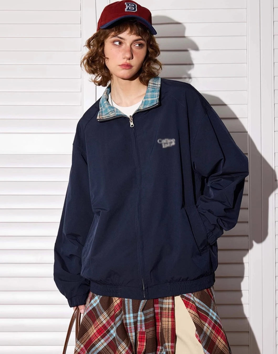 ネイビー無地側のリバーシブルジャケットを着たモデル。立ち姿、横向き。