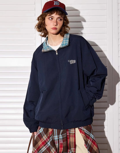 ネイビー無地側のリバーシブルジャケットを着たモデル。立ち姿、横向き。