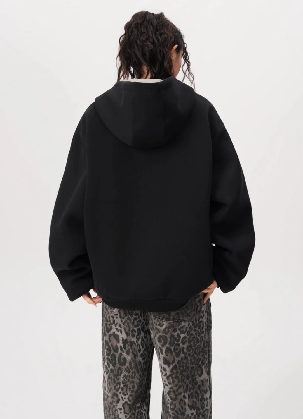 フードを下ろした状態のブラックオーバーサイズジップパーカーの背面シルエットを写した写真