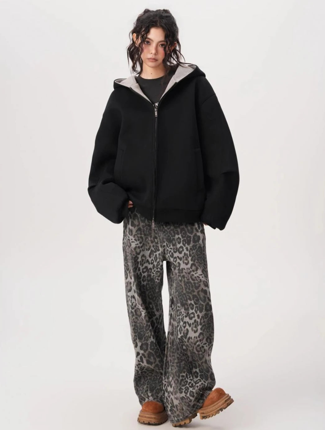 レオパード柄ワイドパンツと合わせたブラックオーバーサイズジップパーカーをモデルが正面から着用している全身写真