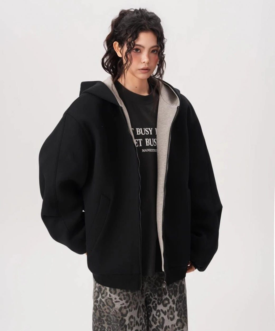 フロントジップを開けてインナーTシャツを見せたブラックオーバーサイズジップパーカーのコーデ写真