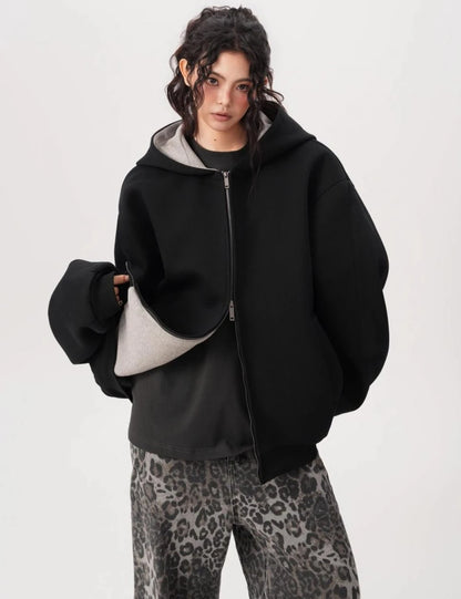 裾を軽く持ち上げて裏地のグレー生地を見せたブラックオーバーサイズジップパーカーのディテール写真