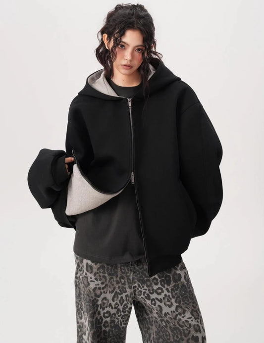 裾を軽く持ち上げて裏地のグレー生地を見せたブラックオーバーサイズジップパーカーのディテール写真