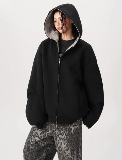 横向き気味のポーズでブラックオーバーサイズジップパーカーのフードとボリュームシルエットを見せている写真