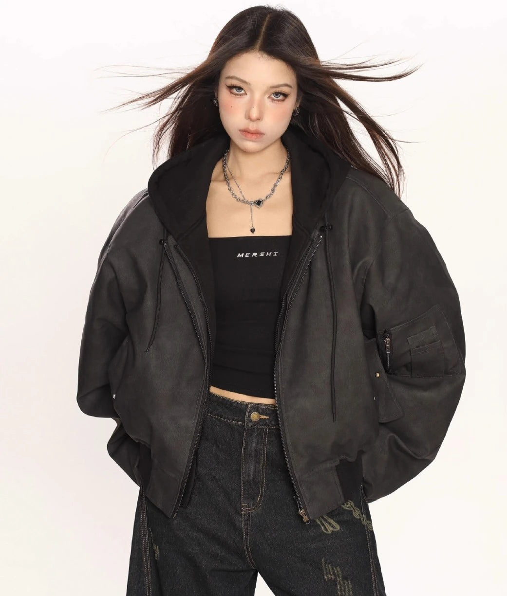 ブラックのオーバーサイズボンバージャケットのジップを少し開け、黒のチューブトップを見せたモデルの上半身ショット