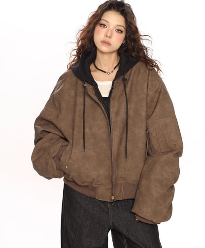 ブラウンのオーバーサイズボンバージャケットと黒パーカーを重ね着したモデルの正面上半身ショット