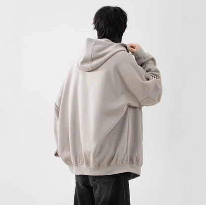 ライトベージュのパーカーを着用した男性モデルの後ろ姿。背中のドレープ感とシンプルなデザイン。