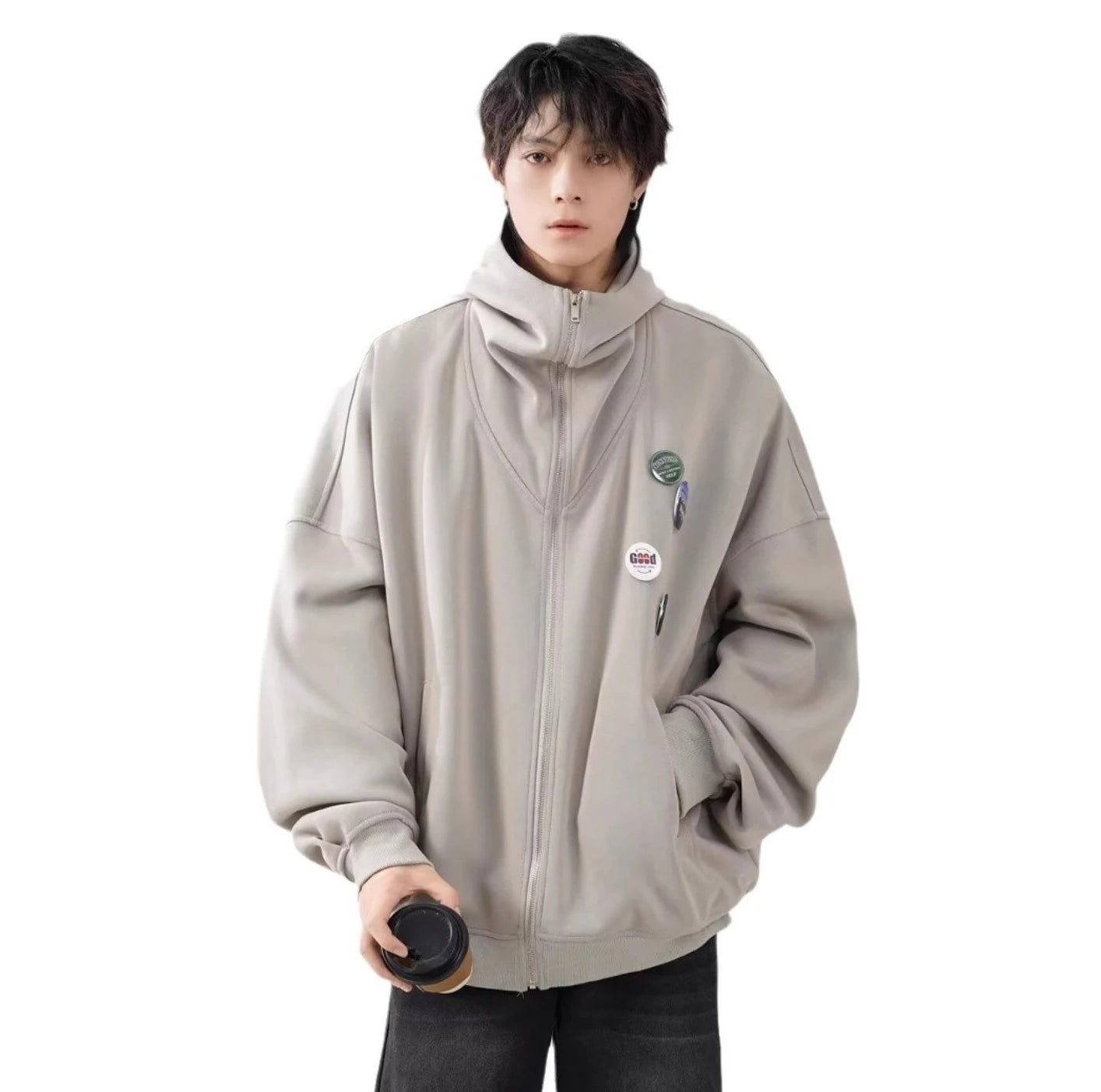 ライトベージュのパーカーを着用した男性モデルの正面写真。コーヒーカップを持ち、カジュアルなストリートスタイル。