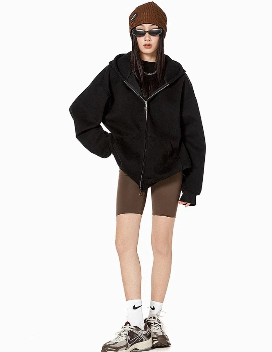 ブラックのオーバーサイズジップパーカーとブラウンのバイカーショーツ、スニーカーを合わせたモデルの正面全身コーデ