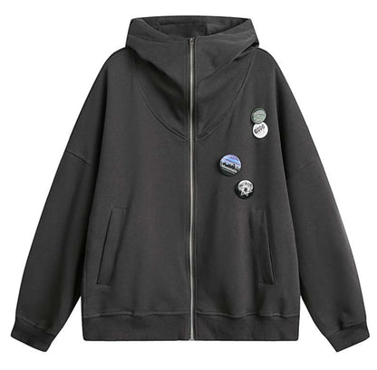 ダークブラウンのジップアップパーカーの平置き（単体）写真。胸元の缶バッジ装飾とポケットのデザイン。
