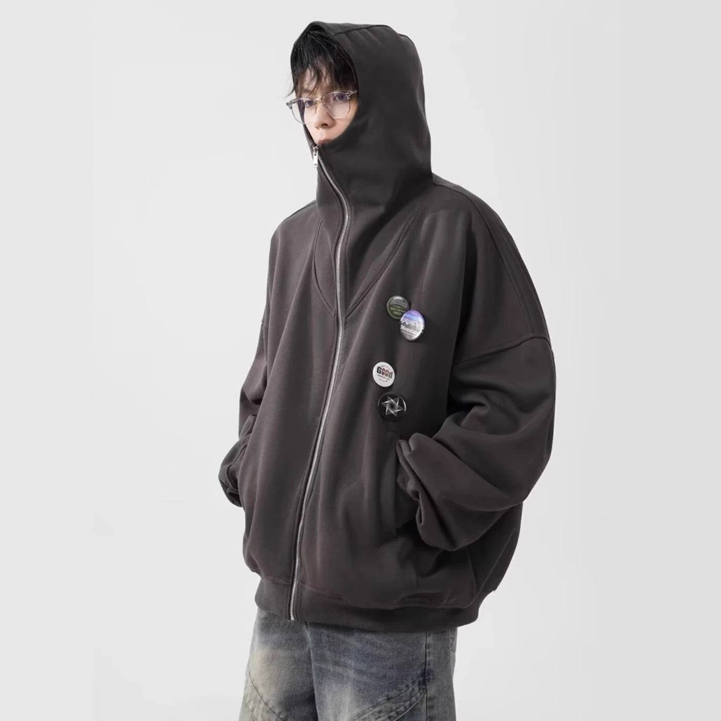 ダークブラウンのパーカーを着用した男性モデルの横顔。フードの立ち上がりと袖のボリューム感がわかる。