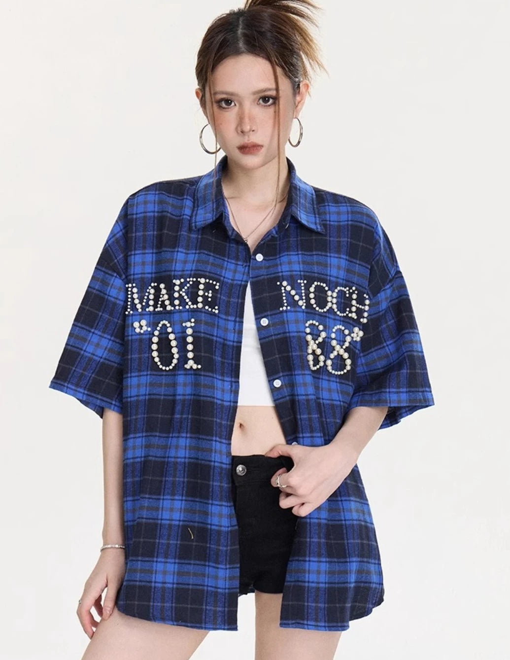 胸元にパールレタリングが入ったブルー×ネイビーチェック柄オーバーサイズシャツのフロントスタイリングカット。ゆったりシルエットと長め丈が分かる画像。