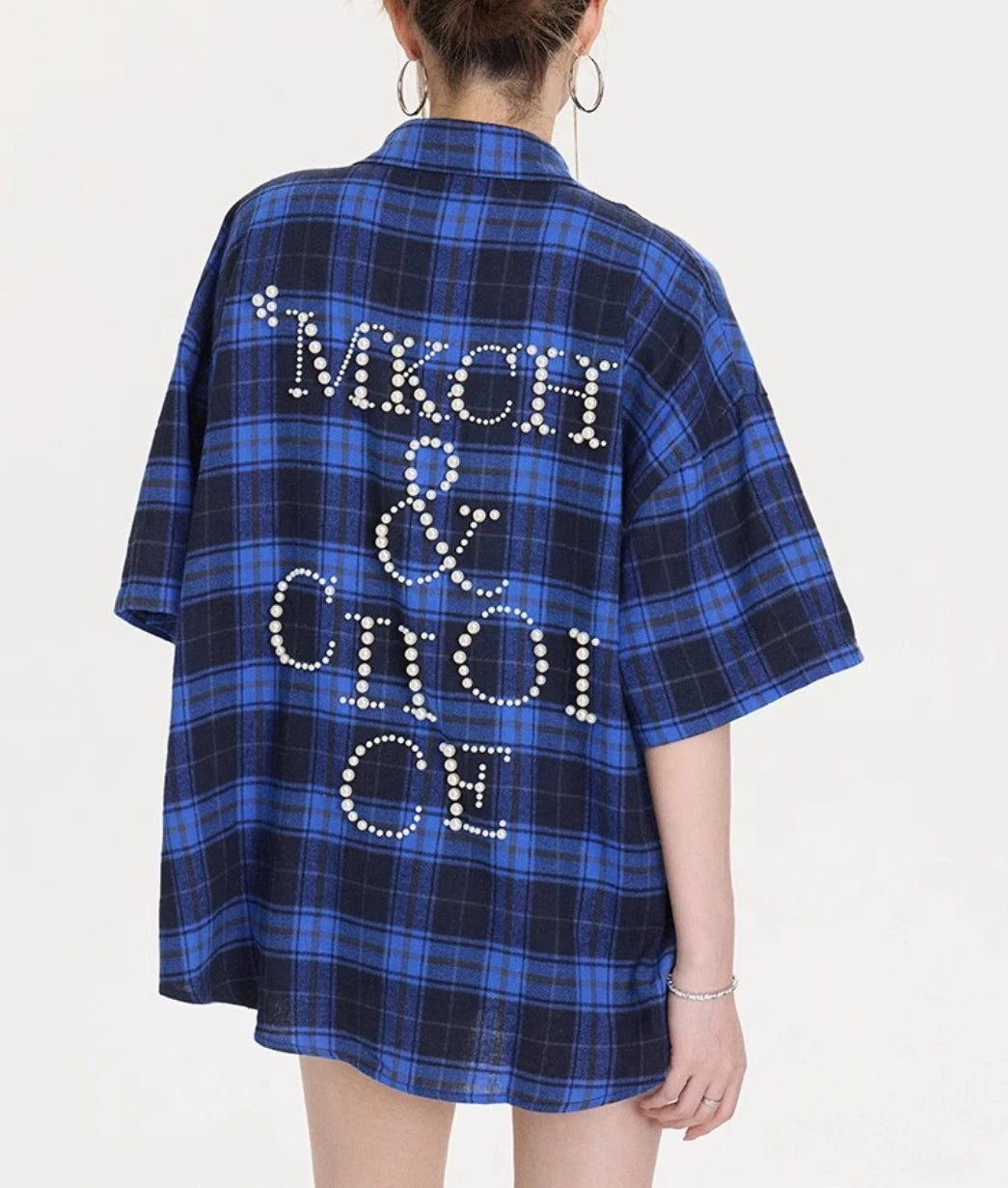 背中に大きなパールレタリングデザインが施されたブルー×ネイビーチェック柄オーバーサイズシャツのバックショット。たっぷりした身幅とドロップショルダーが分かる画像。
