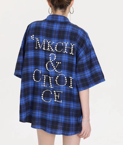 背中に大きなパールレタリングデザインが施されたブルー×ネイビーチェック柄オーバーサイズシャツのバックショット。たっぷりした身幅とドロップショルダーが分かる画像。
