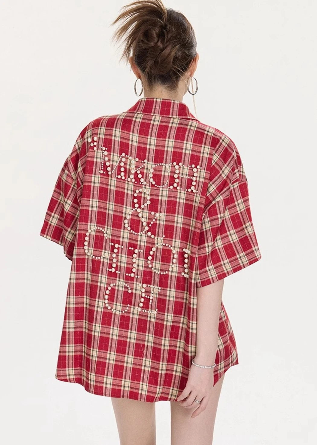 背面に大きなパールレタリングデザインが入ったレッドチェック柄オーバーサイズシャツのバックショット。ゆったりとしたシルエットが分かる画像。