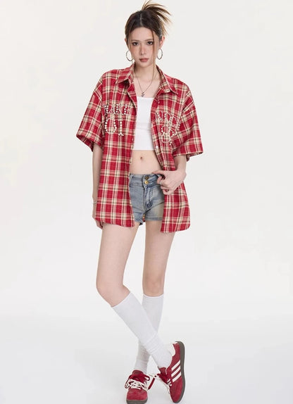 レッドチェック柄オーバーサイズシャツをデニムショートパンツとスニーカーに合わせた全身コーディネート写真。ストリート感のあるカジュアルスタイル。