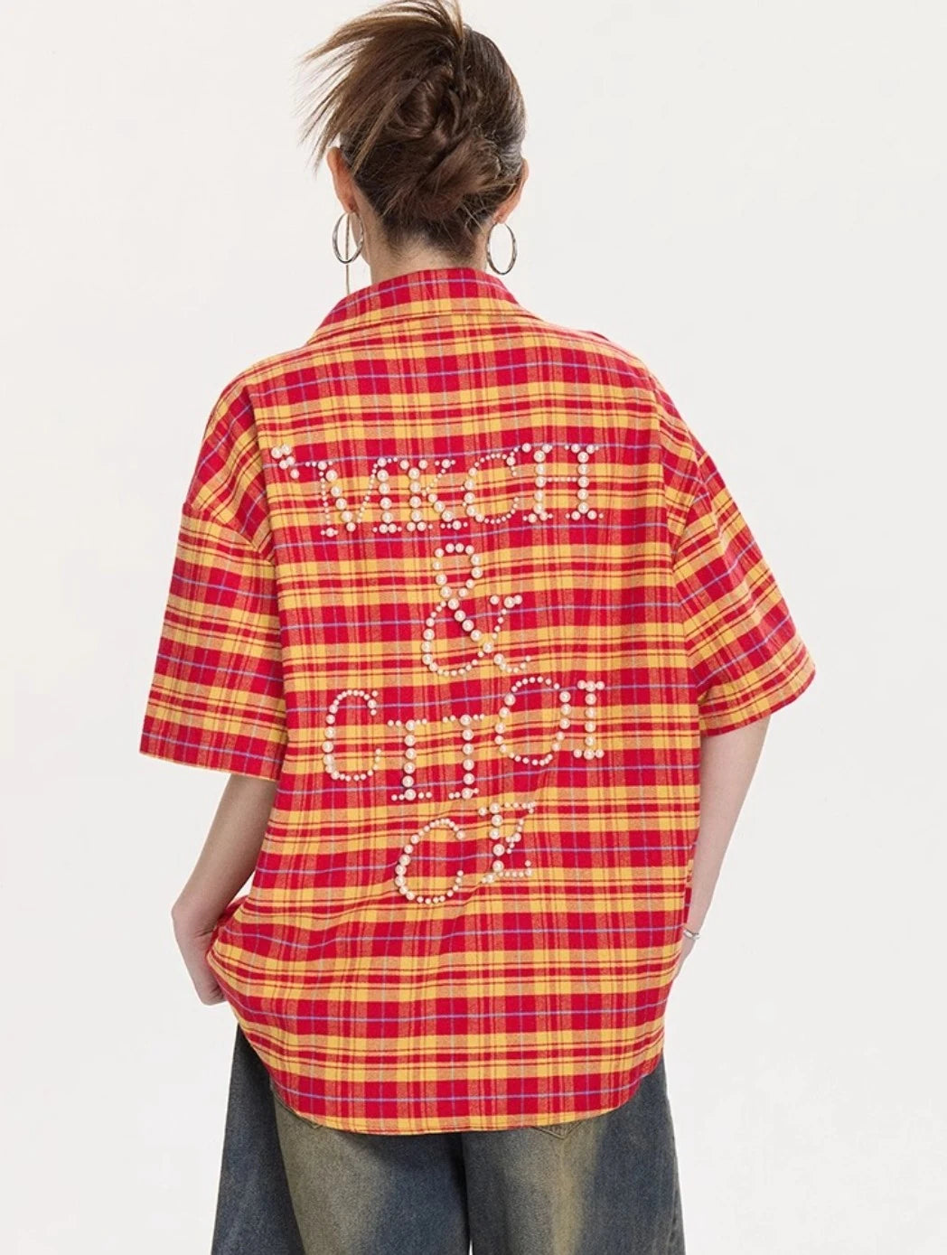 背中に大きなパールレタリングデザインが入ったイエロー×レッドチェック柄オーバーサイズシャツのバックショット。ゆったりとした丈感が分かる画像。