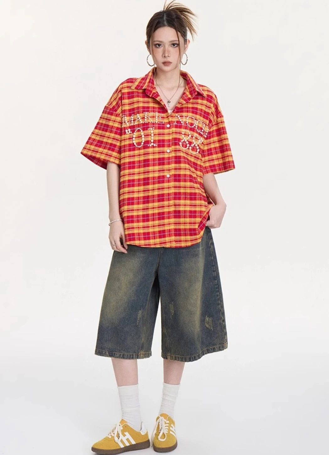 イエロー×レッドチェック柄オーバーサイズシャツをワイドなデニムショーツとイエロースニーカーに合わせた全身コーデ写真。カジュアルストリートなスタイル。