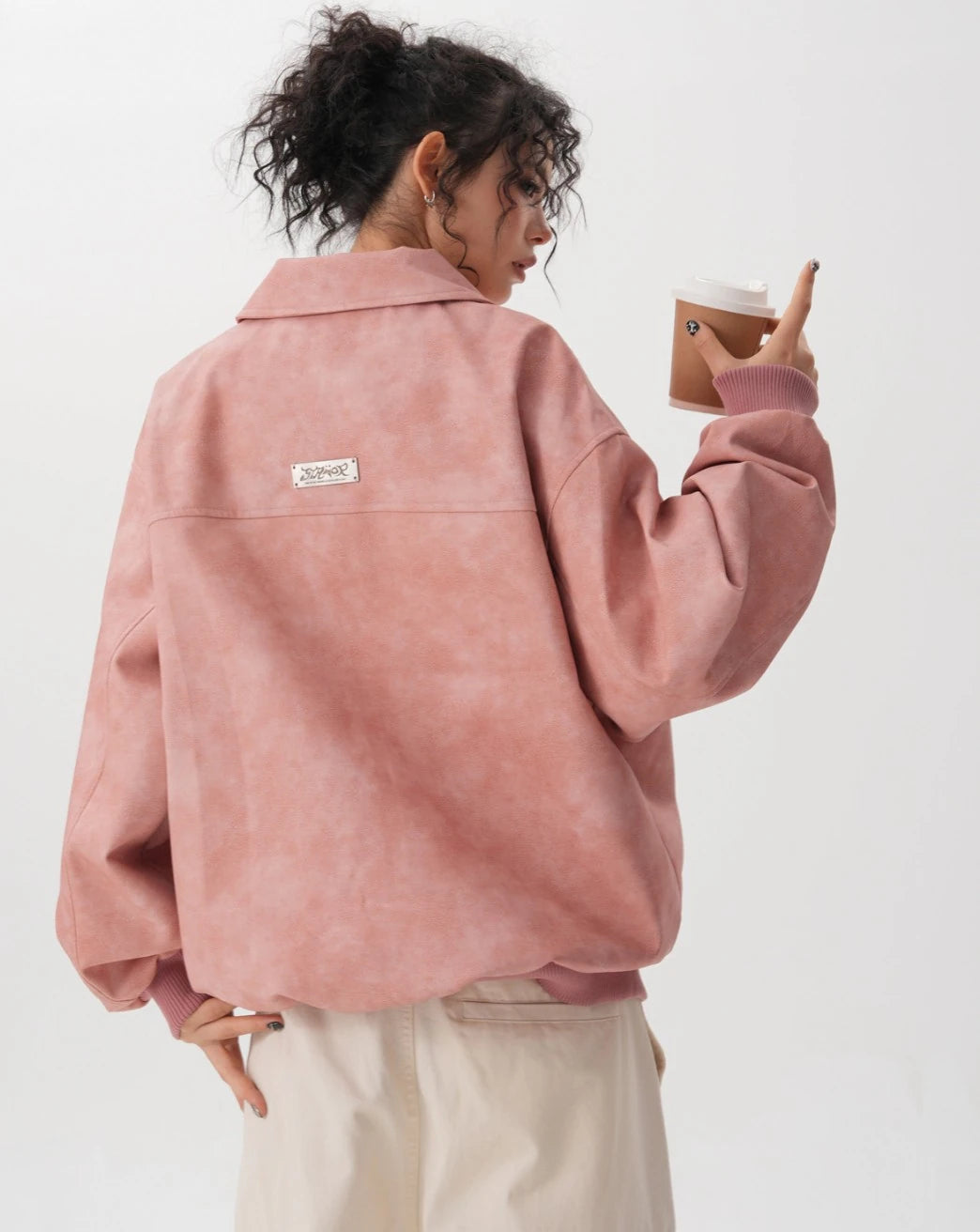 ピンクのビッグフード付きボアブルゾンを着たモデルの後ろ姿。上半身。
