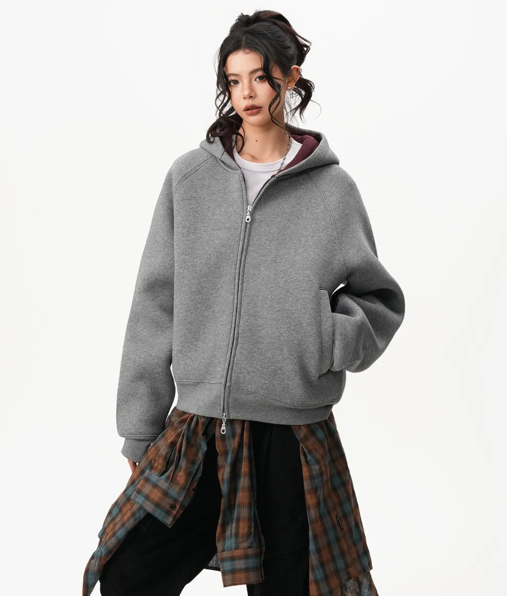 ポケットに片手を入れたモデルがグレーのラグランジップパーカーをラフに着こなしている正面写真