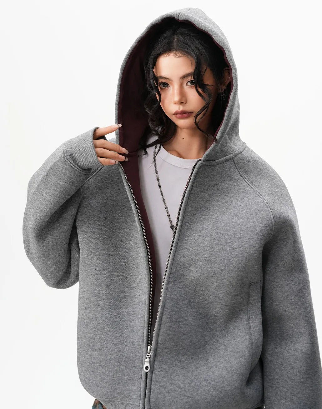 フードをかぶったモデルの上半身をアップで撮影したグレーラグランジップパーカーのディテール写真