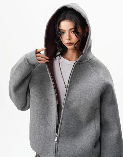 フードをかぶったモデルの上半身をアップで撮影したグレーラグランジップパーカーのディテール写真