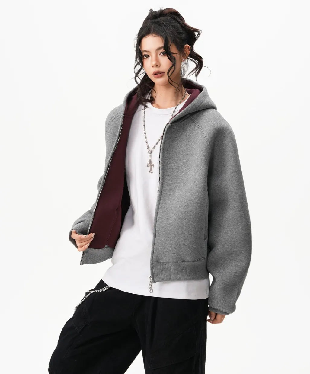 ボルドー裏地のフードが覗くグレーのラグランジップパーカーを前開きで着たモデルのコーディネート写真