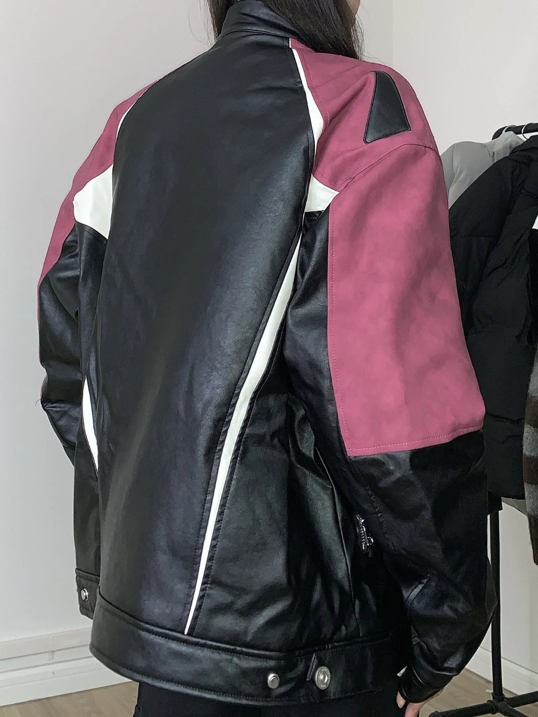 レッドとブラックの配色ライダースジャケットを着たモデルの背面。