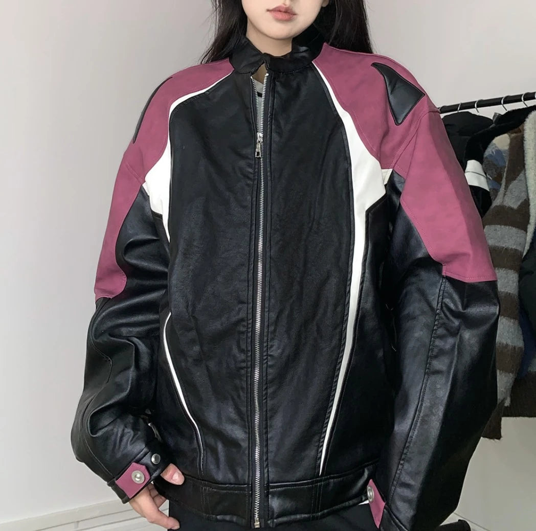 レッドとブラックの配色ライダースジャケットを着たモデル。ジッパーを閉めた状態。