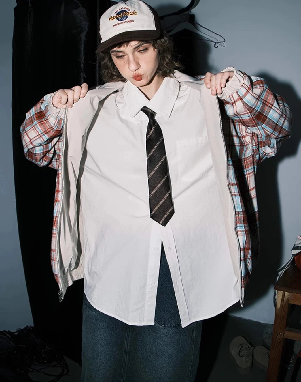 赤チェック柄側のリバーシブルジャケットを裏返しているモデル。シャツとネクタイ。