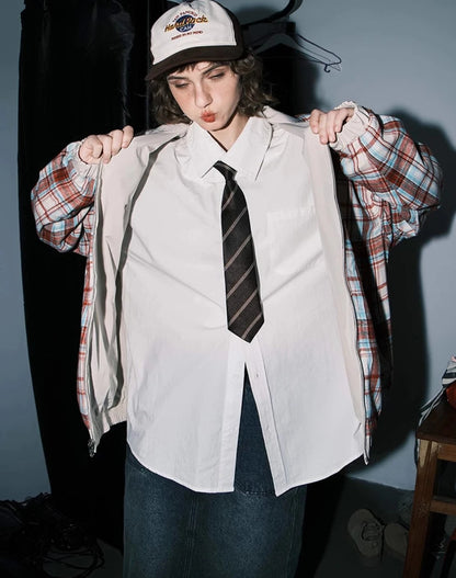 赤チェック柄側のリバーシブルジャケットを裏返しているモデル。シャツとネクタイ。