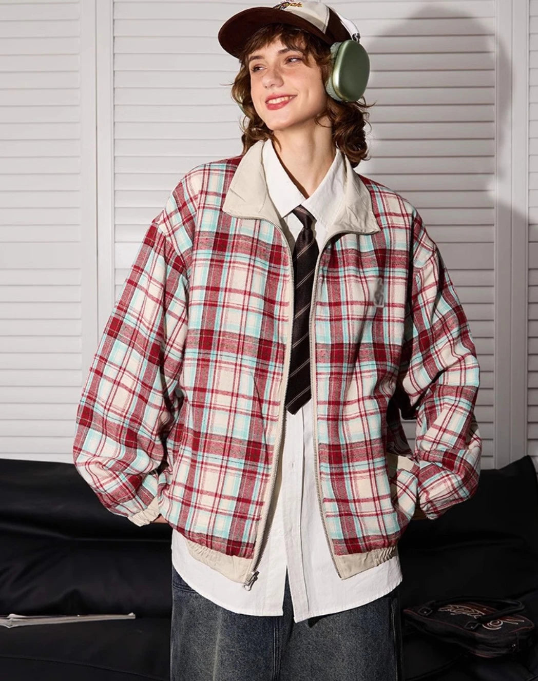 赤チェック柄側のリバーシブルジャケットを着たモデル。立ち姿、笑顔。