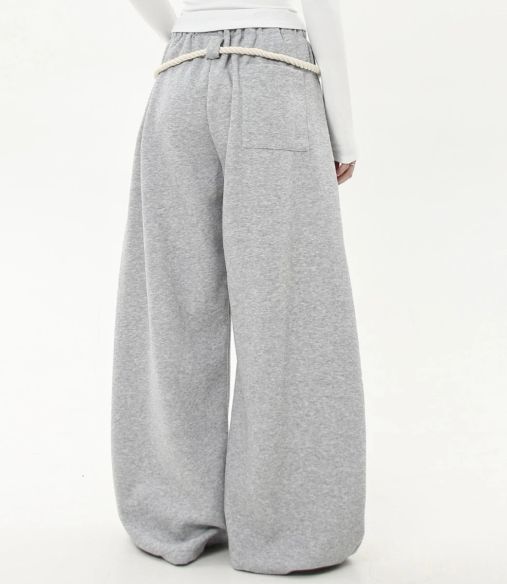 ロングの白ロープ紐が垂れたグレーワイドスウェットパンツの背面ショット。裾までたっぷりとボリュームのあるシルエットが特徴。
