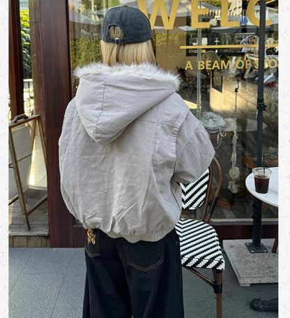 ファー付きブルゾンとキャップを着用した後ろ姿。黒のワイドデニムとのコーディネート。