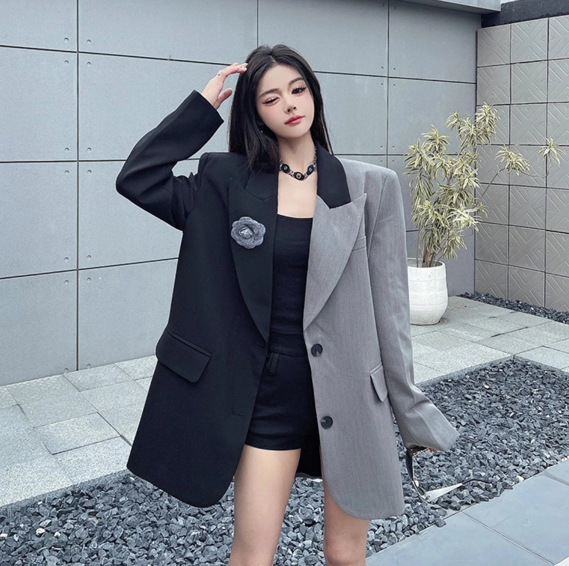 黒とグレーのジャケットを着用した屋外でのポートレート。自然光の下で見る生地の質感とシルエット。