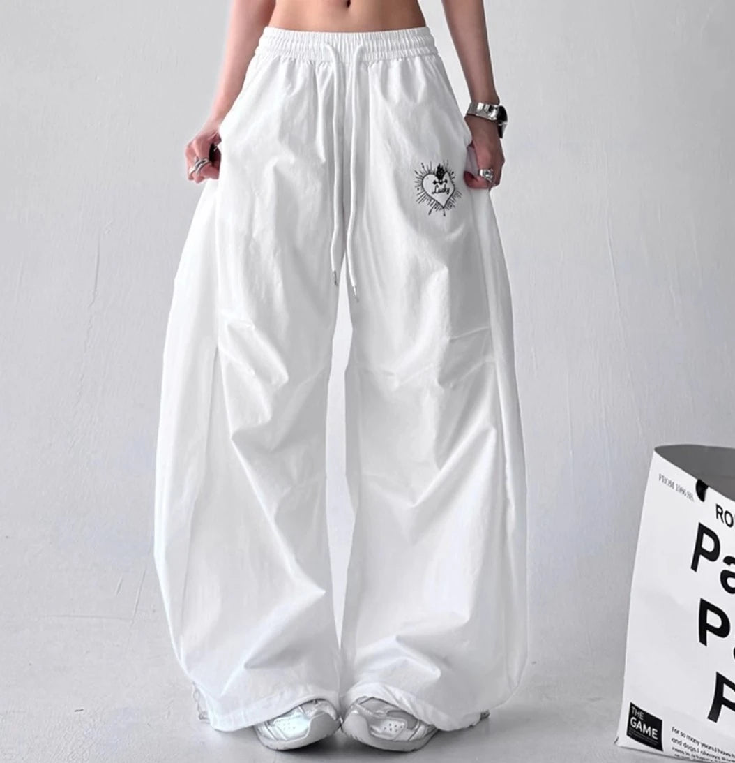 フロントスタイルの白いワイドパンツ。左ポケット付近にある『Lucky』という文字が入ったハートの刺繍が特徴。